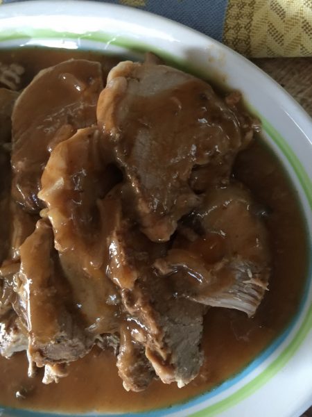 tenderloin and gravy in a bowl sitting on table