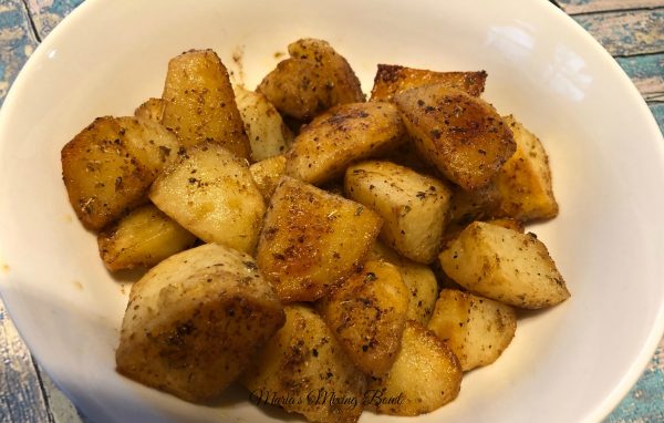 Ranch Roasted Potatoes in a white bowl wit ha blue table under 
