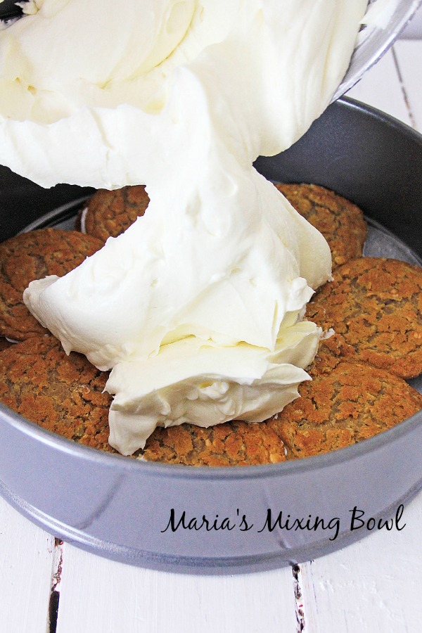 cheesecake filling being poured into springform pan with oatmeal cookies as the crust