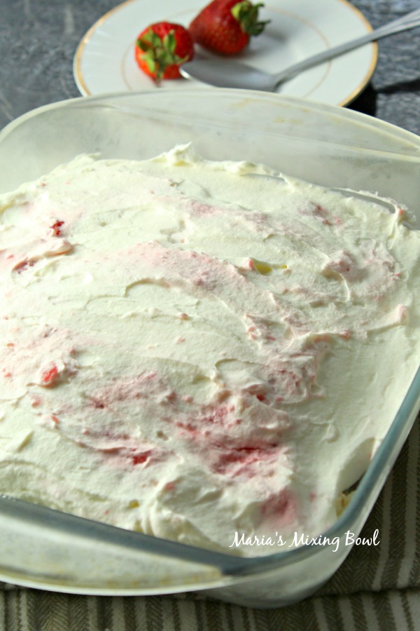 Strawberry Angel Food Cake Dessert view of pan with angel food cake and berries dessert spread into the pan with whipped cream on top