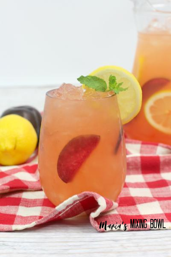Citrus Plum Whiskey Smash with fruit and pitcher