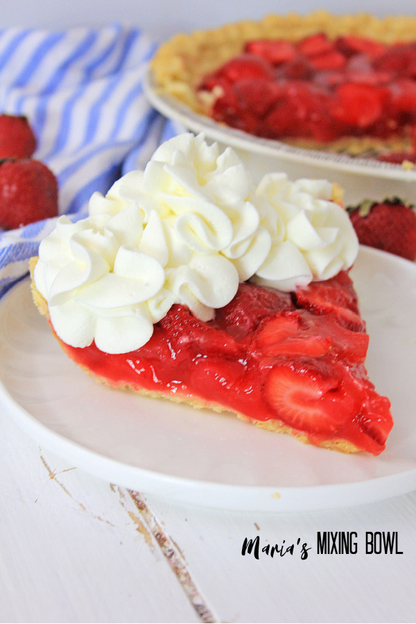 Easy Fresh strawberry Pie is in a white plate with a blie and white striped napkin