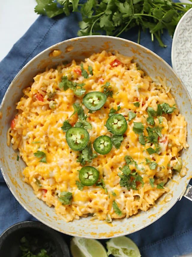 cheesy potatoes in a skillet with jalapeno topping