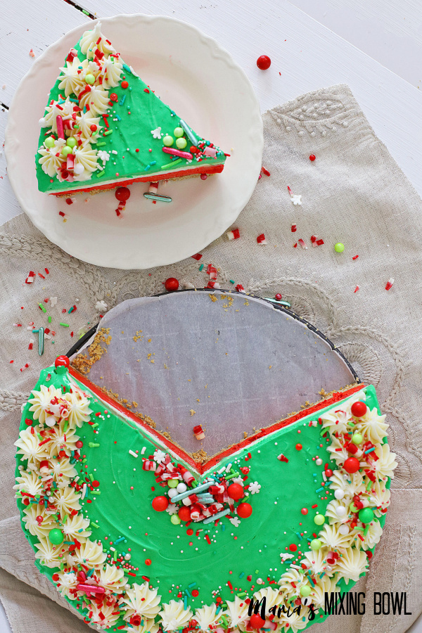 no bake Christmas cheesecake on white plate and cake on the bottom on a beige napkin