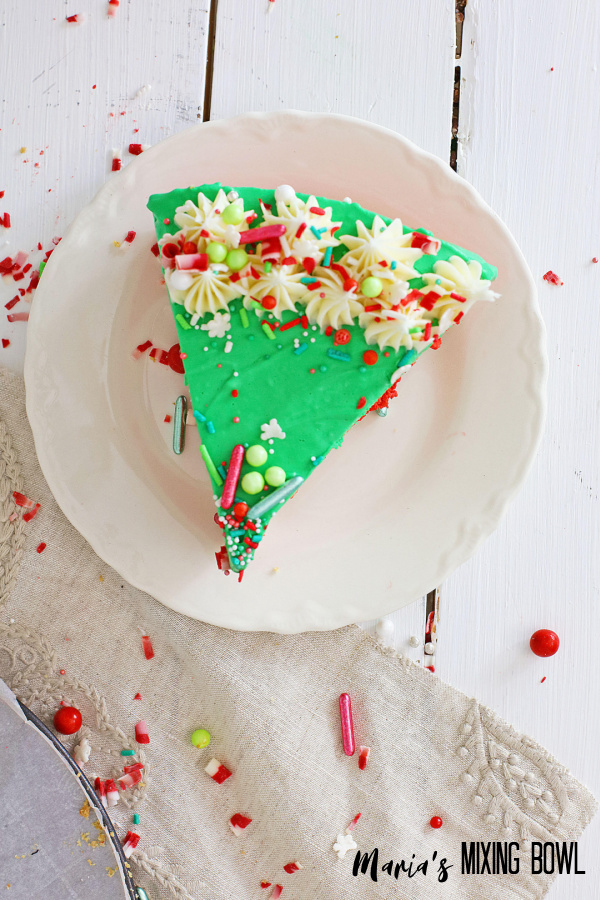 slice of Christmas cheesecake dessert with sprinkles on a white plate