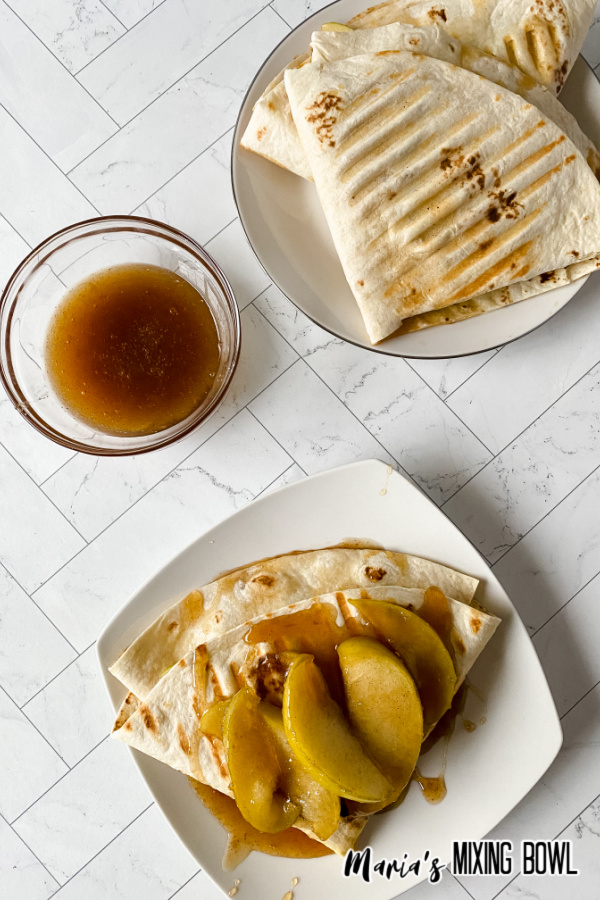 Two white plates with caramel apple wraps.