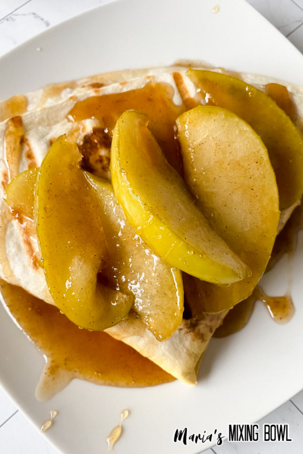 Close up of apples and caramel topping the wrap.