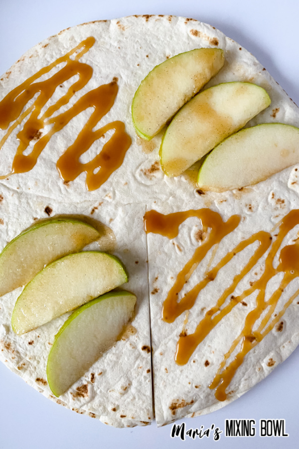 Caramel and apple slices on tortilla before cooking.