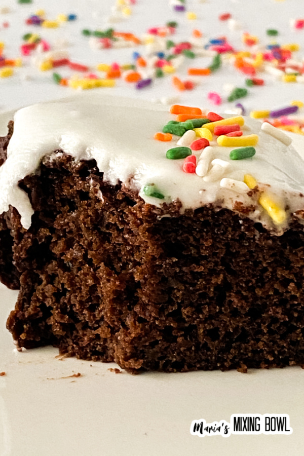 Slice of cake with white frosting and sprinkles