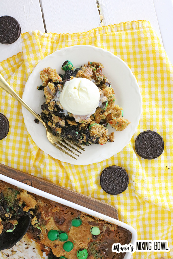 Overhead shot of dump cake topped with ice cream on white plate