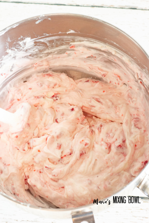 Cream filling with strawberries mixed in in mixing bowl