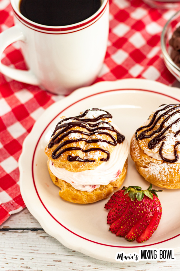 Two puffs with sliced strawberry on white plate