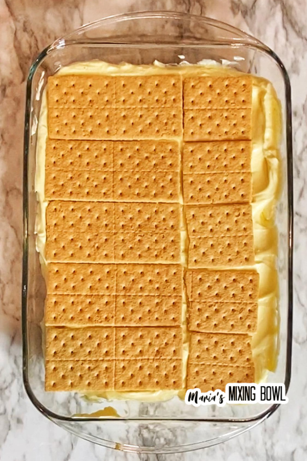 Graham crackers layered over pudding in glass baking dish