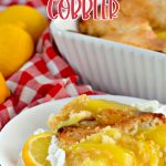 Baked lemon cobbler on a white plate lemons and white and red napkin