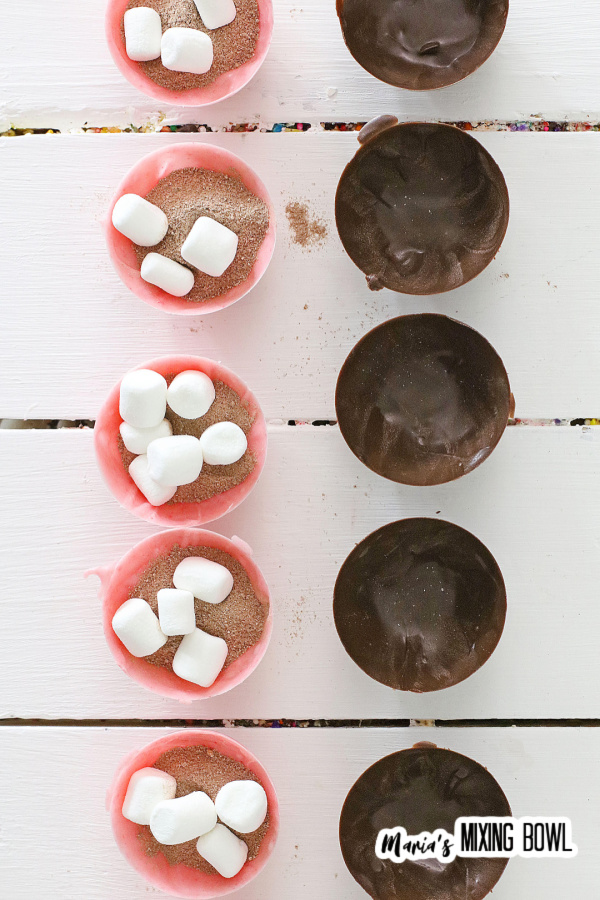 Overhead shot of cocoa bombs filled with ingredients and ready to be filled