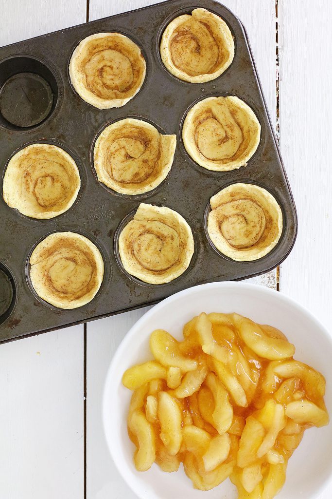 cinnamon rolls and apples in a white bowl