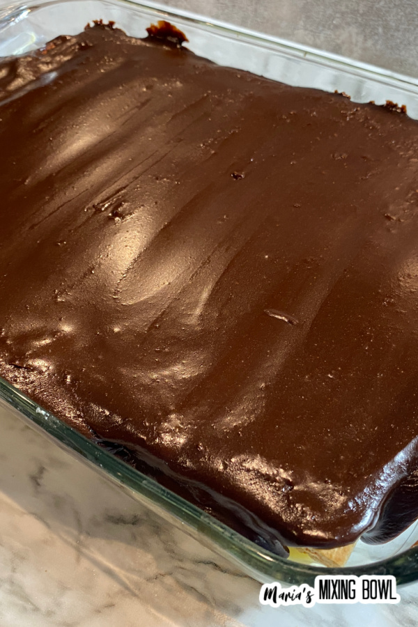 Whole chocolate eclair cake in glass baking dish.