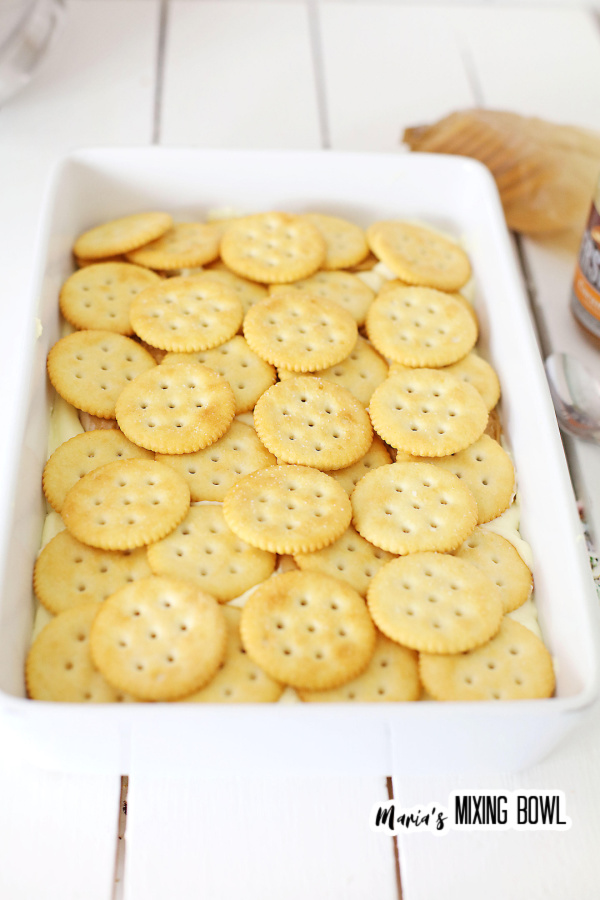 Ritz crackers lining bottom of white baking dish