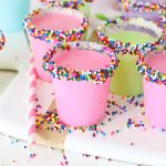 A white board with birthday cake shots in pink green and blue