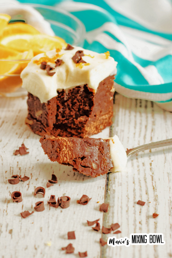 frosted brownie with a fork on a white board