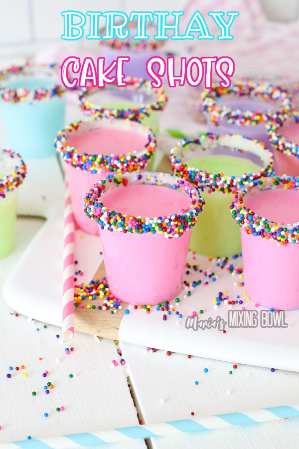 Birthday cake shots rimmed with sprinkles on cutting board