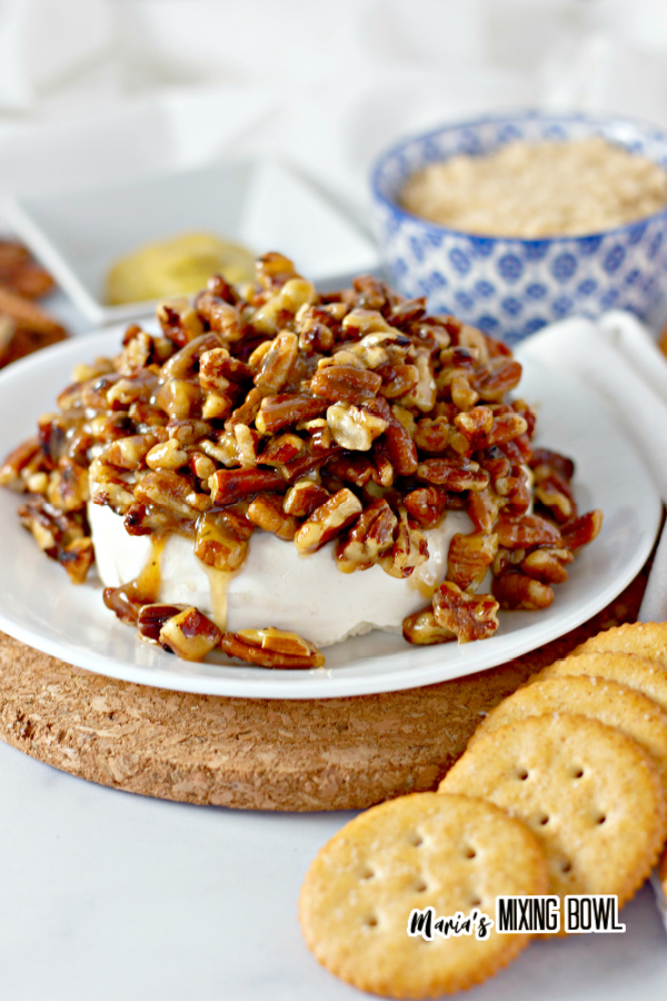 sweet and savory cheese spread with pecans on a white plate  