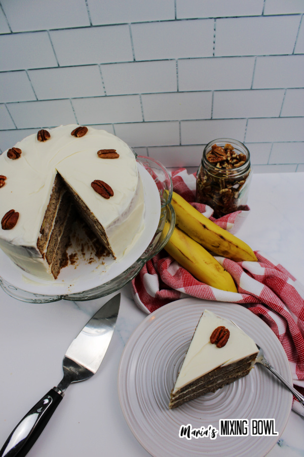 Overhead shot of cake slice on plate next to the rest of the cake on a cake stand