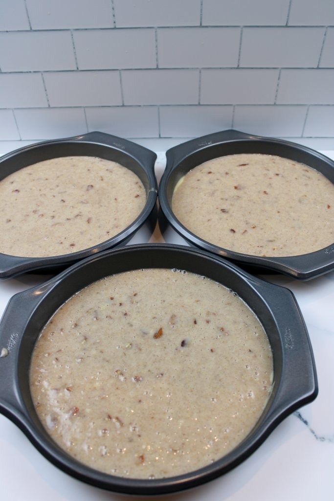 Three pans of cake batter to be cooked and used for old fashioned hummingbird cake recipe