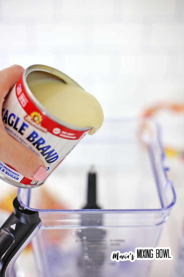 Closeup shot of can of sweetened condensed milk being poured into blender