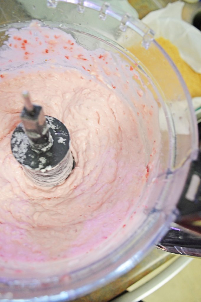 Overhead shot of strawberry cheesecake mixture in food processor