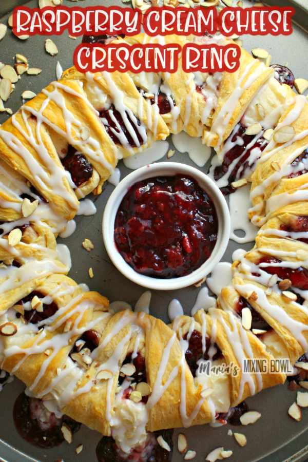 Overhead shot of raspberry cream cheese crescent ring with bowl of raspberry puree in bowl