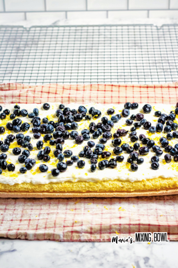 Lemon cake sheet topped with cream cheese mix and blueberries
