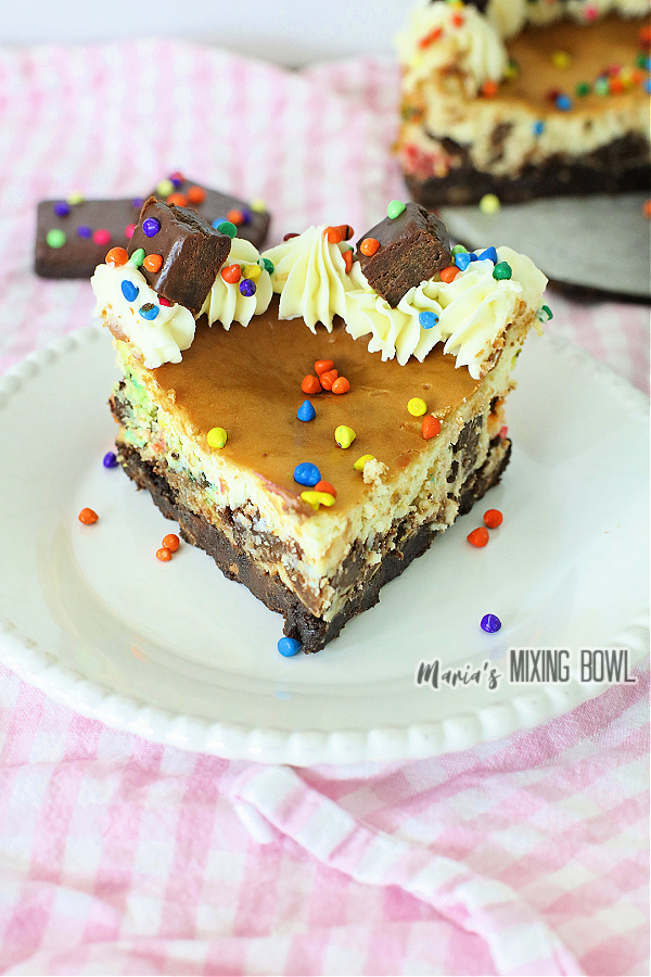 Slice of cosmic brownie cheesecake on white plate