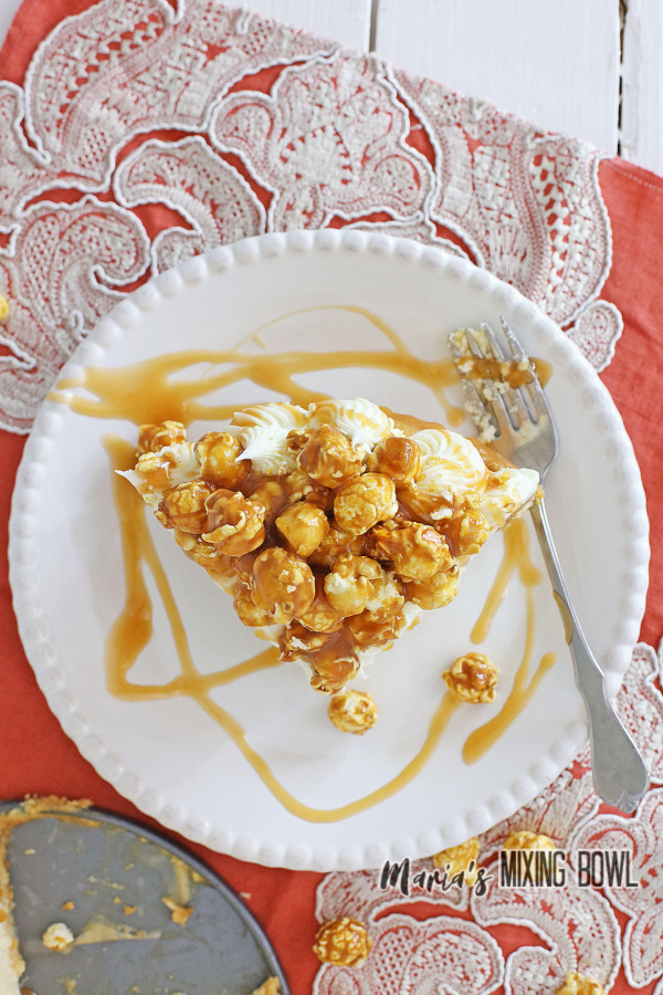 Overhead shot of slice of caramel corn cheesecake with fork on plate
