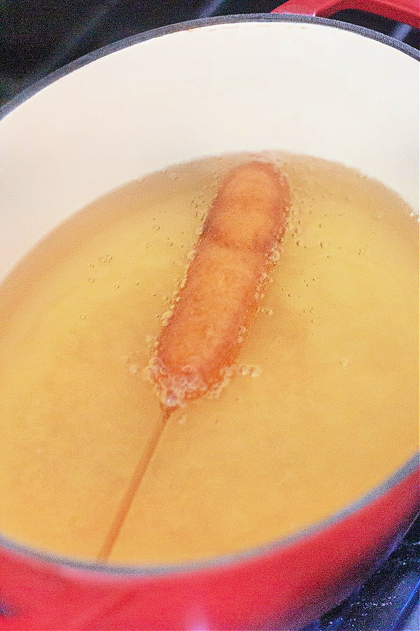 Corn dog being fried in oil