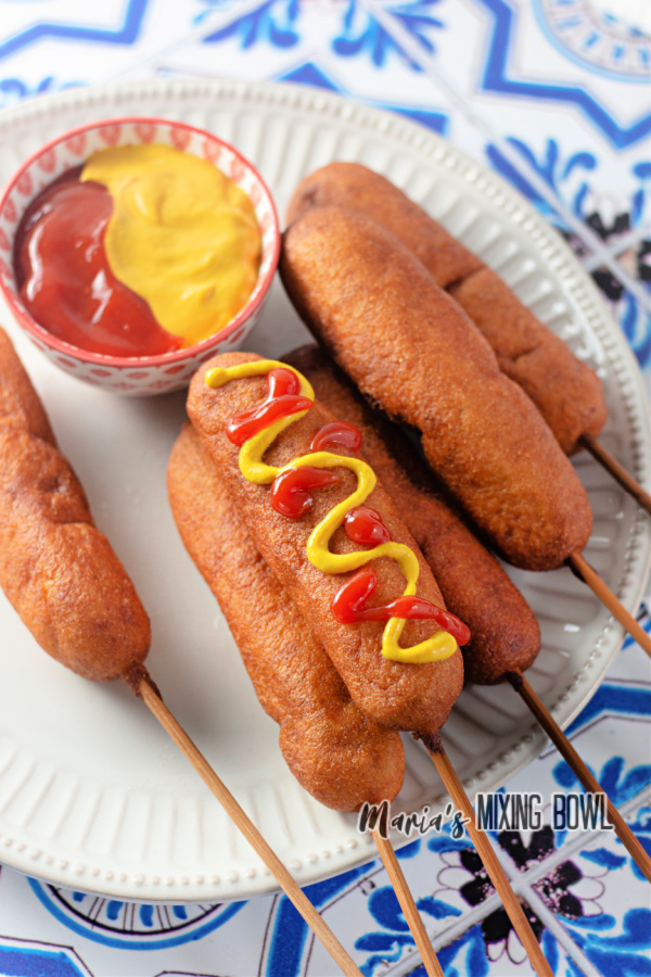 Homemade corn dogs on plate with ketchup and mustard