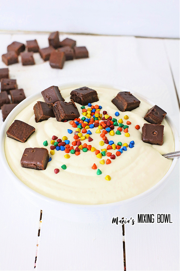 Cheesecake batter topped with brownie bits in white bowl