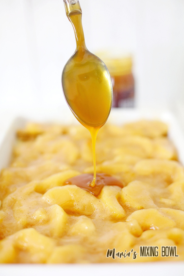 Spoon drizzling caramel sauce onto icebox cake