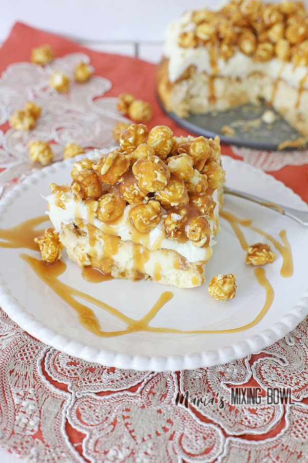 Slice of caramel corn cheesecake on plate with remaining cheesecake on pan in background