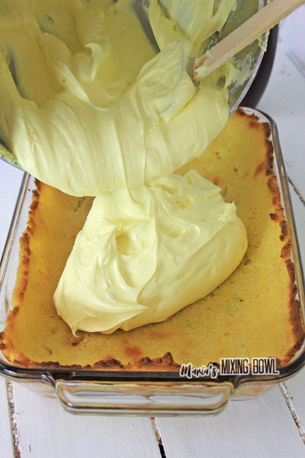 Pouring batter over cream puff crust in baking dish