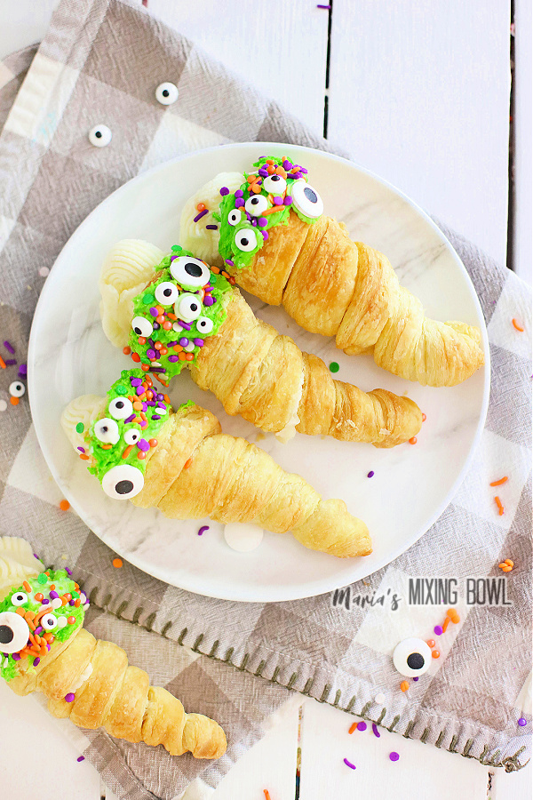 Overhead shot of puff pastry Halloween horns filled with cream on plate