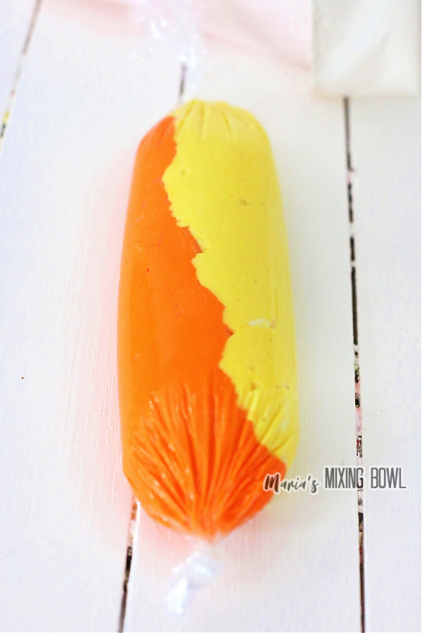 Yellow and orange frosting in clingwrap tube