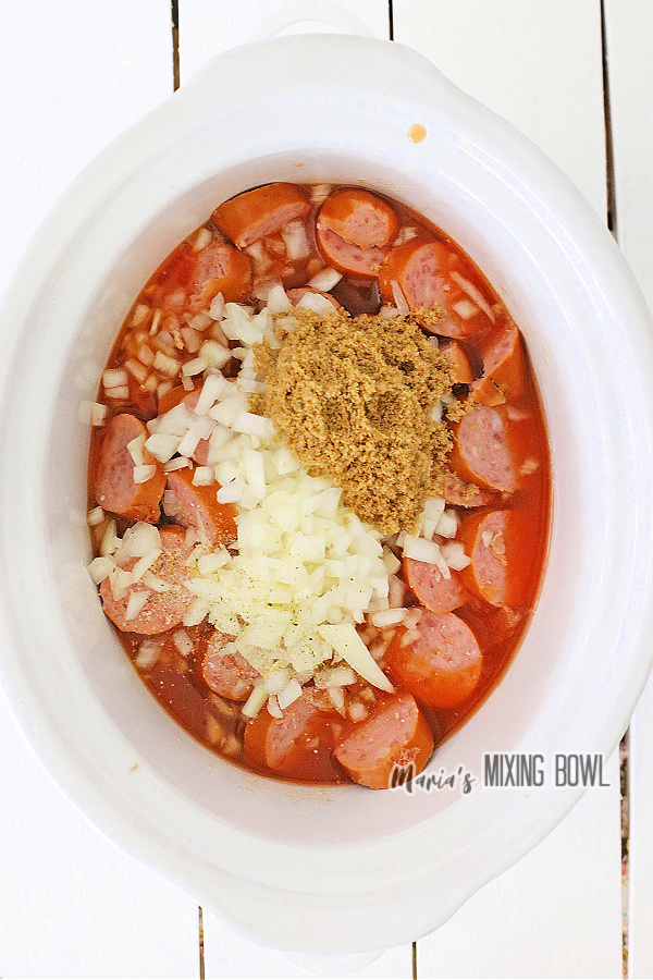 Overehead shot of brown sugar and onions over kielbasa with pork n beans