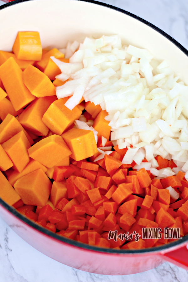 Pot filled with butternut squash, carrots, and onions.