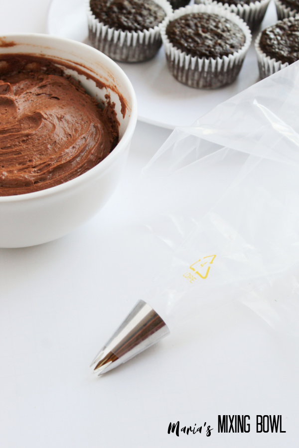 Piping bag with star tip next to bowl of batter.