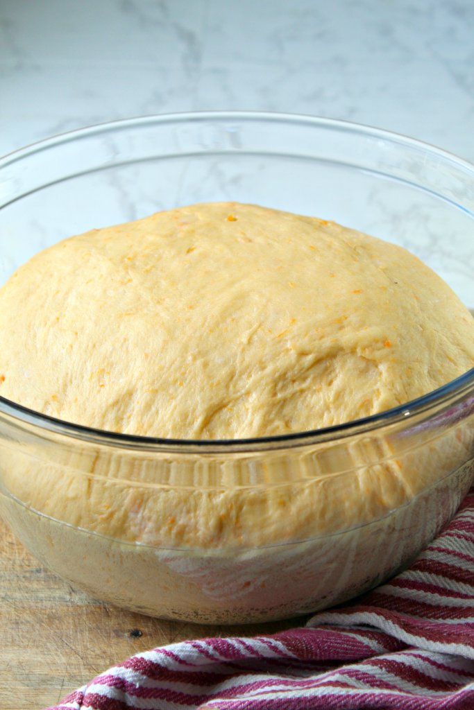 Dinner roll dough rising in glass bowl