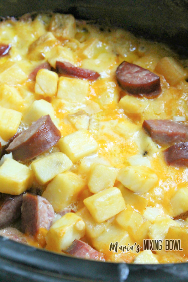Closeup shot of cheesy kielbasa hashbrown casserole in slow cooker