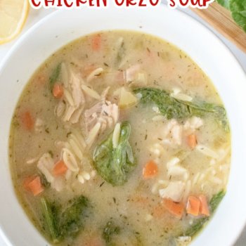 bowl or easy lemon chicken orzo soup in a white bowl with lemon slices and spinach