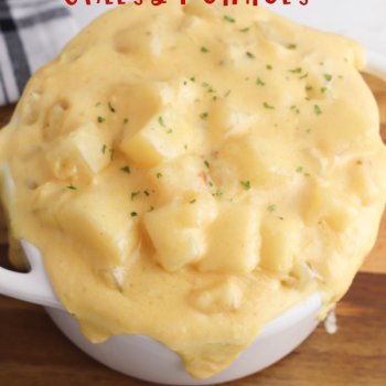 slow cooker cheesy potatoes in a white crock on a board