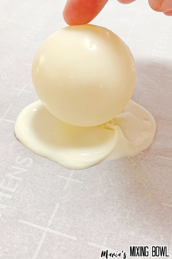 White chocolate cocoa bomb sitting on melted white chocolate